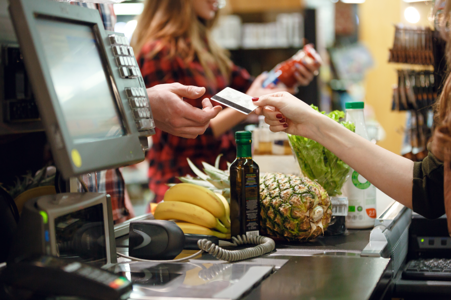 Човек плаща с кредитна карта в супермаркета.