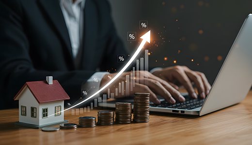 house, laptop and stack of coins symbolizing growth in revenie